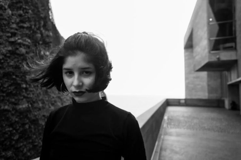 Cinthya Miranda posando con un edificio detrás en blanco y negro