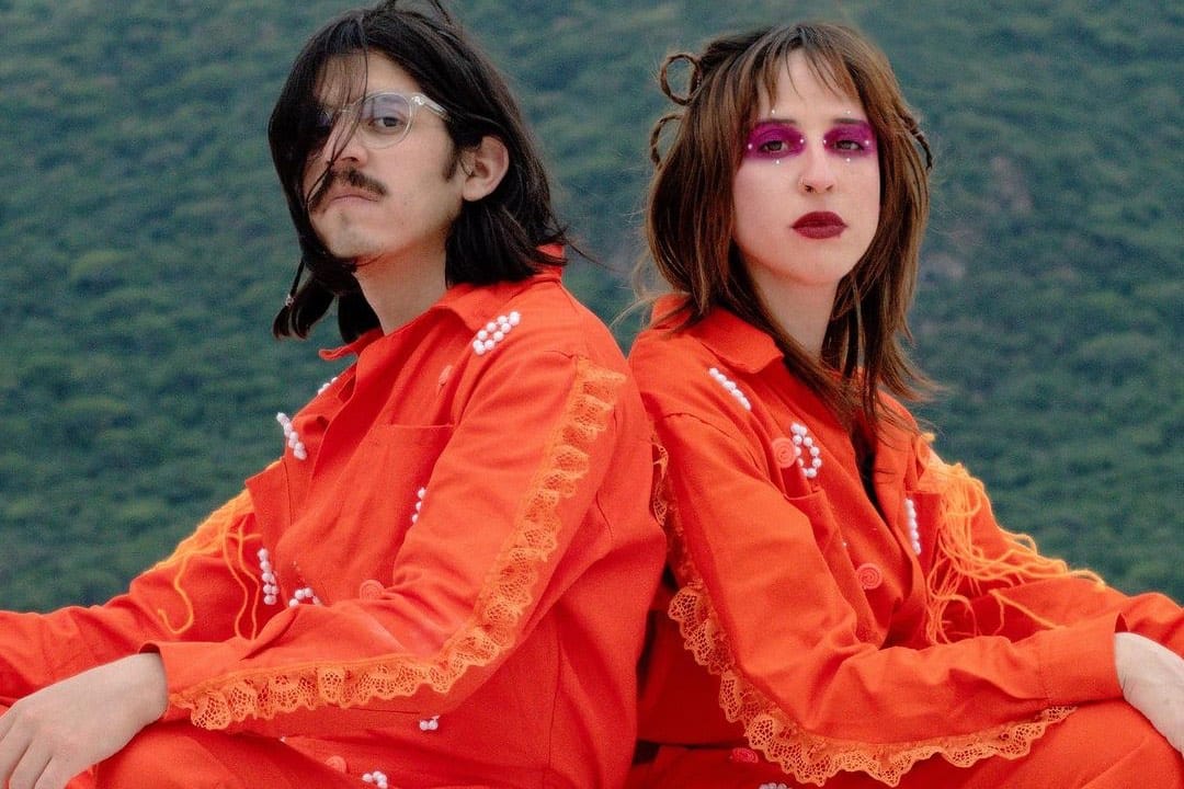 Budaya con trajes naranjas sobre un fondo de vegetación