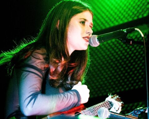 Celevis tocando en concierto con una guitarra en mano