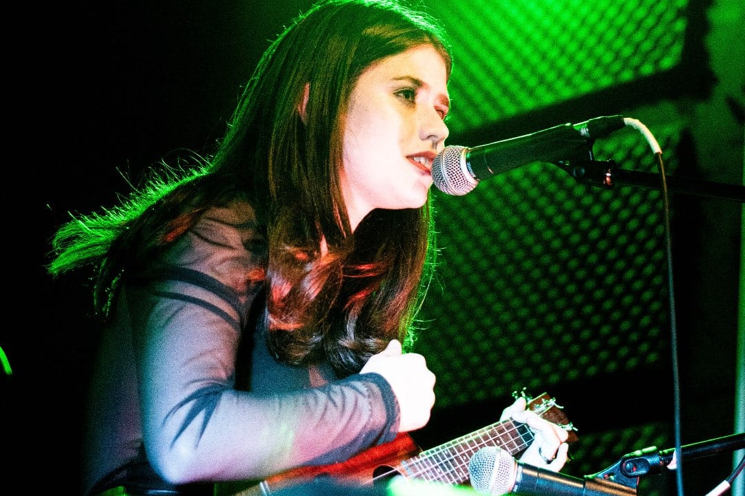 Celevis tocando en concierto con una guitarra en mano