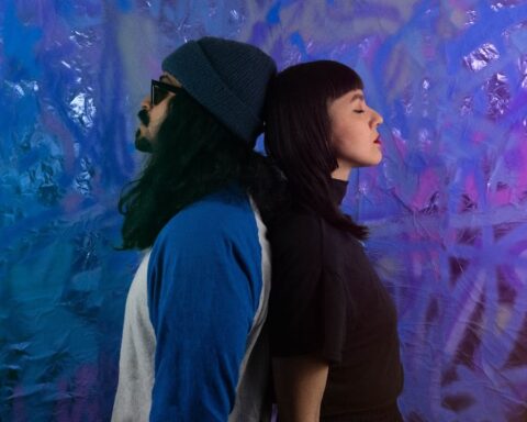 ES&M posando en un fondo morado a espalda contra espalda