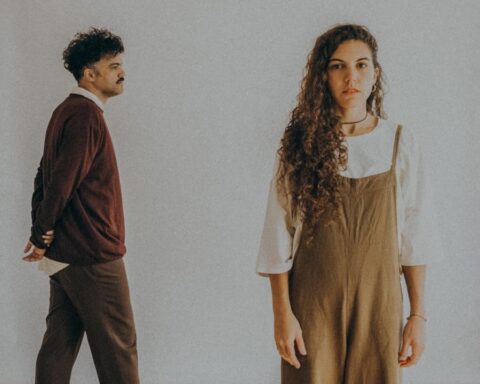 Lorena Blume y Alex Ferreira con un muro blanco de fondo
