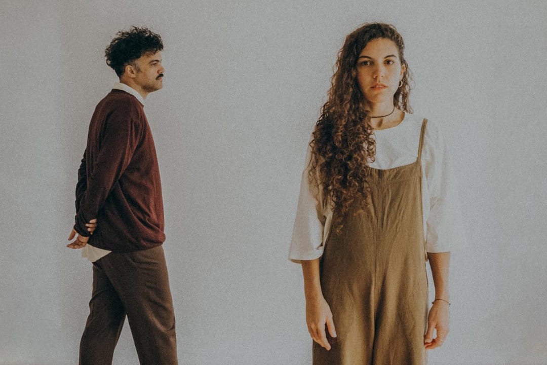 Lorena Blume y Alex Ferreira con un muro blanco de fondo