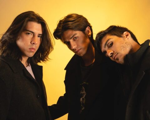 El trío chileno Dodo con vestimentas negras posando en un fondo dorado