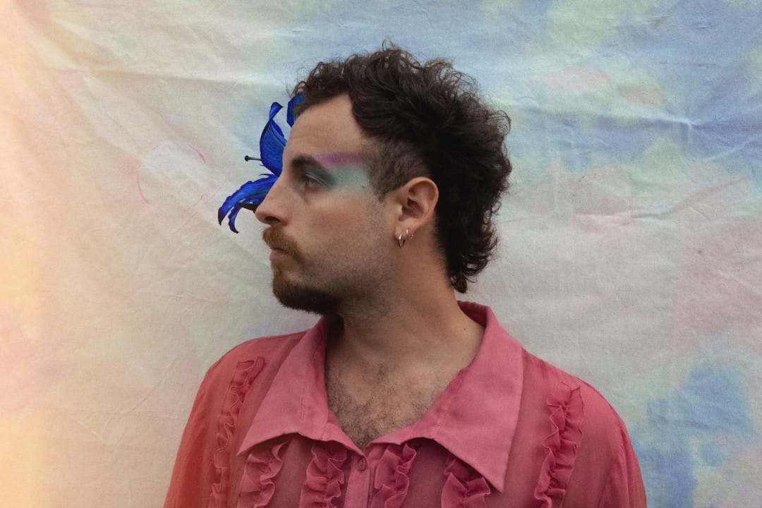 El cantante Gerikö posa de perfil con una flor morada en su cabeza