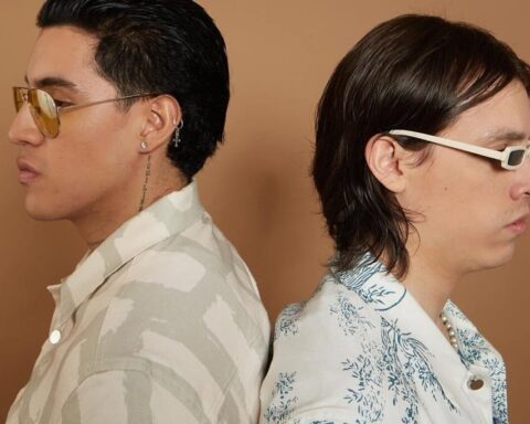 Los Inzul posando de espalda contra espalda en un fondo marrón