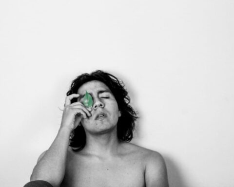 Mial con los ojos cerrados y sosteniendo una hoja de árbol