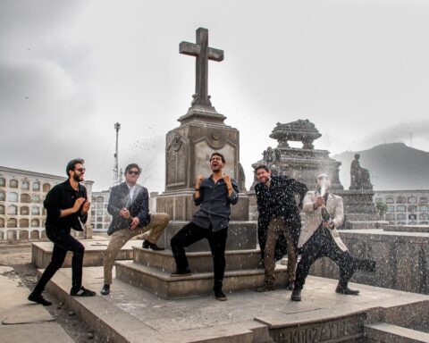 La banda peruana Perros Santos sosteniendo botellas de champagne en un cementerio de Lima