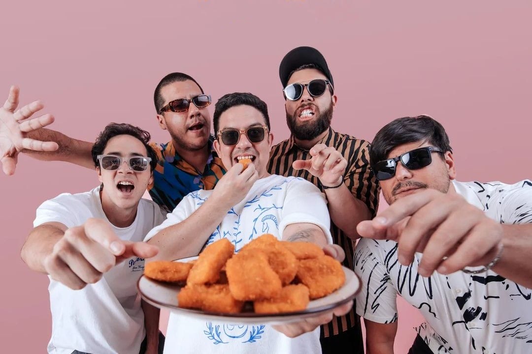 Nave Ascensor junto a Mauricho y El Joven Paiva sosteniendo un plato de nuggets