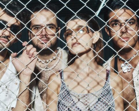 Disco Bahía posando detrás de un cerco de metal