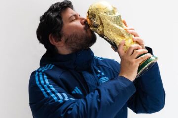 Santiago Motorizado sosteniendo y besando la Copa del Mundo
