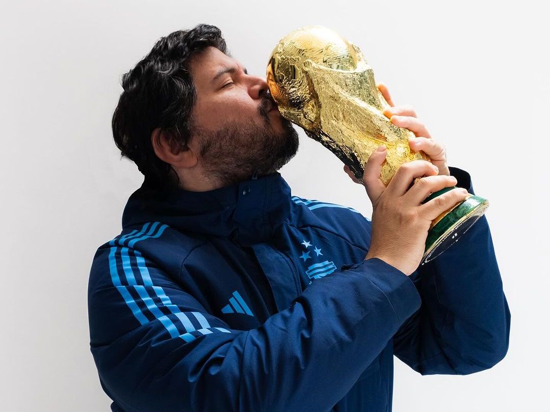 Santiago Motorizado sosteniendo y besando la Copa del Mundo