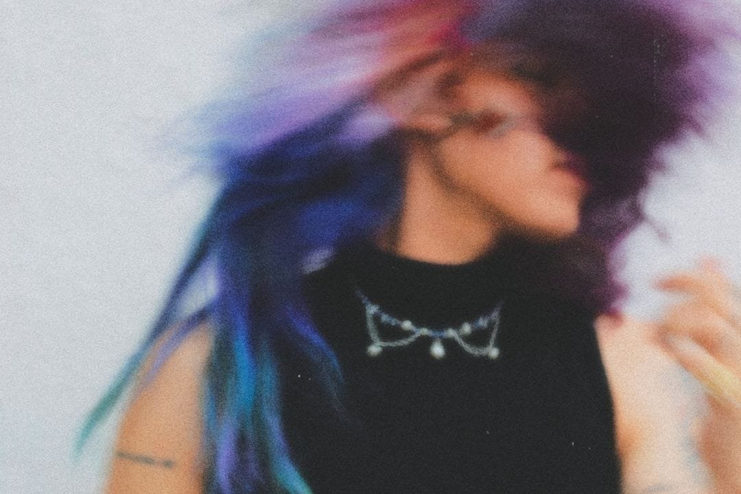 Aqnu moviendo su pelo con el lente desenfocado