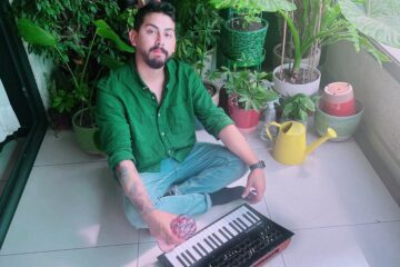 Camilo Abarca sentado en un balcón con su sintetizador