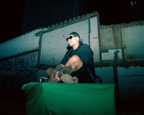 Kriska con lentes de sol sentado entre viviendas