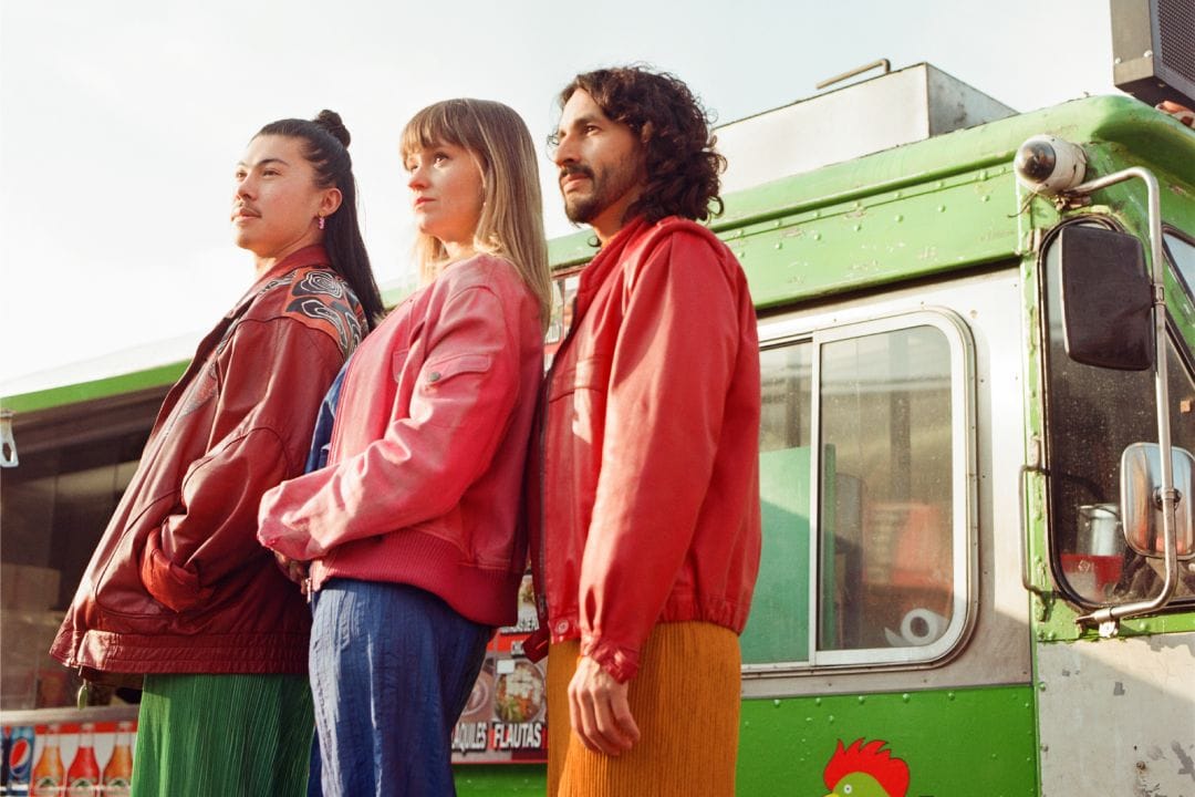 Tipa Tipo posando frente a un bus de transporte público