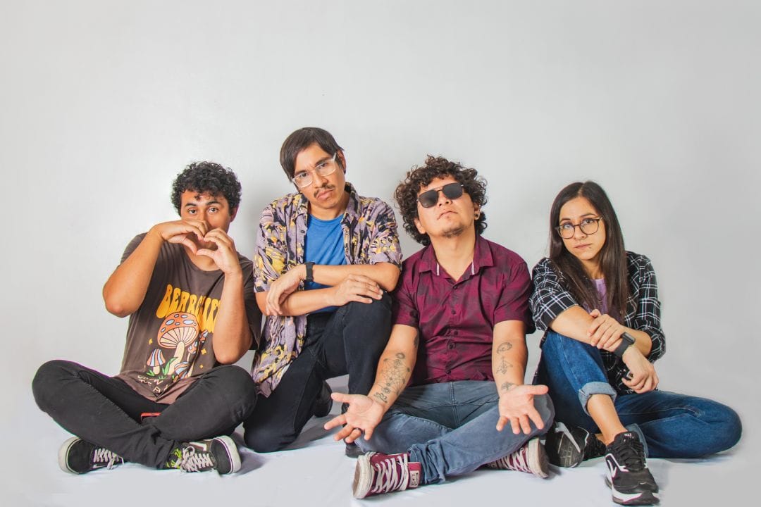 Verano del 83 sentados con un fondo gris