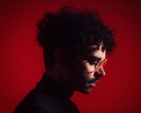 André Ubilla posando de perfil con un fondo rojo sombrío