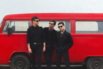 Los Estroboscópicos posando con una combi de color rojo