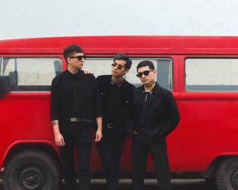 Los Estroboscópicos posando con una combi de color rojo