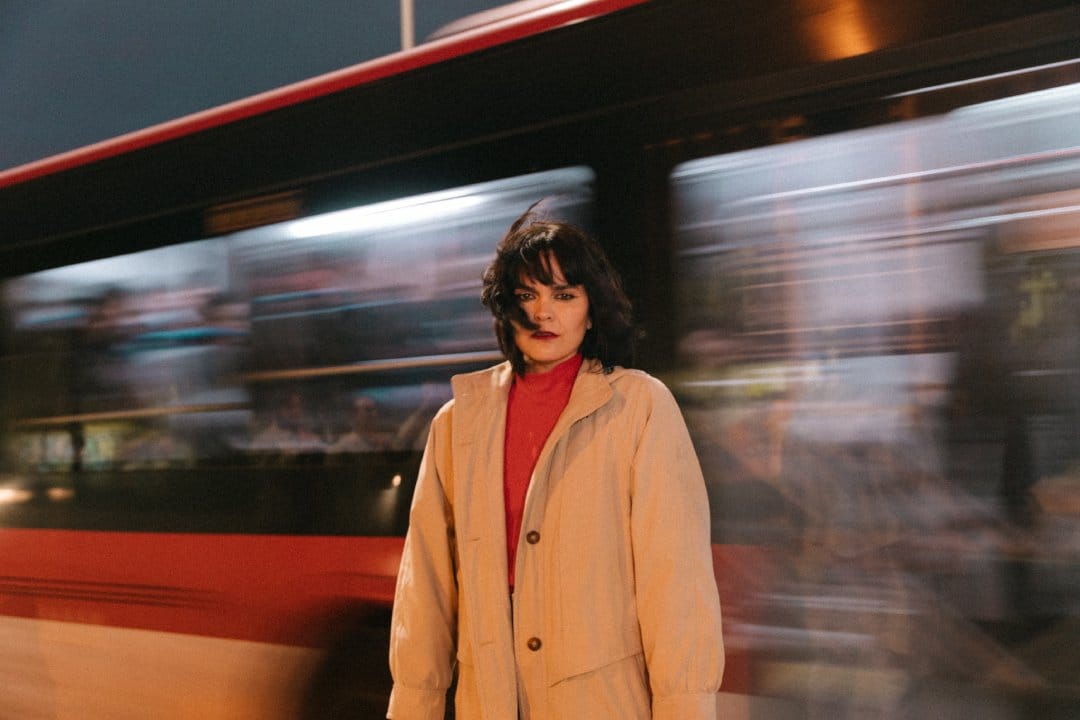 Camila Moreno con un bus en movimiento detrás