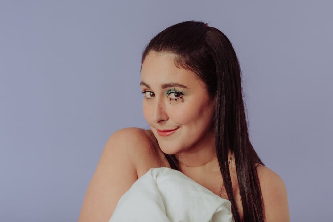 Luciana Arispe posando con un fondo lila