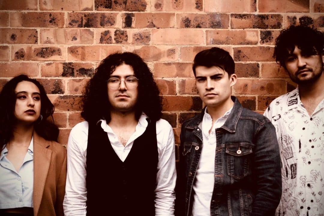 Lxs Parker poscando con una pared de ladrillos detrás