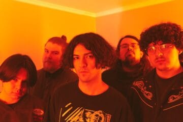 Los integrantes de Déjenme Dormir posan en un cuarto iluminados por luz amarilla