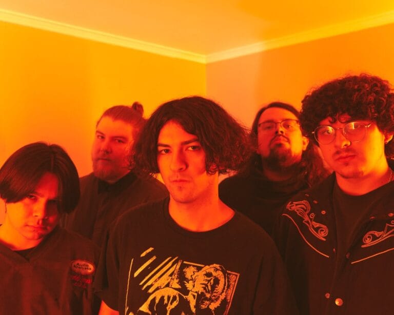 Los integrantes de Déjenme Dormir posan en un cuarto iluminados por luz amarilla