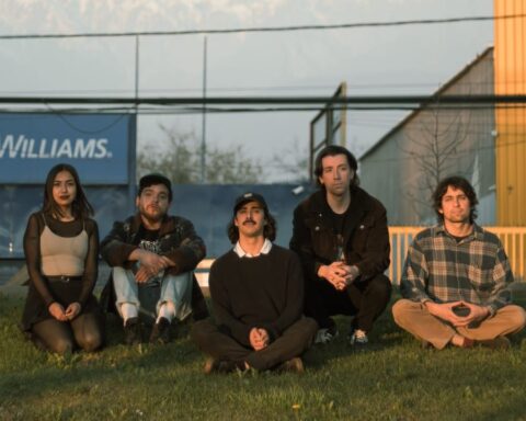 El Cómodo Silencio de los que Hablan Poco posando sentados sobre el jardín