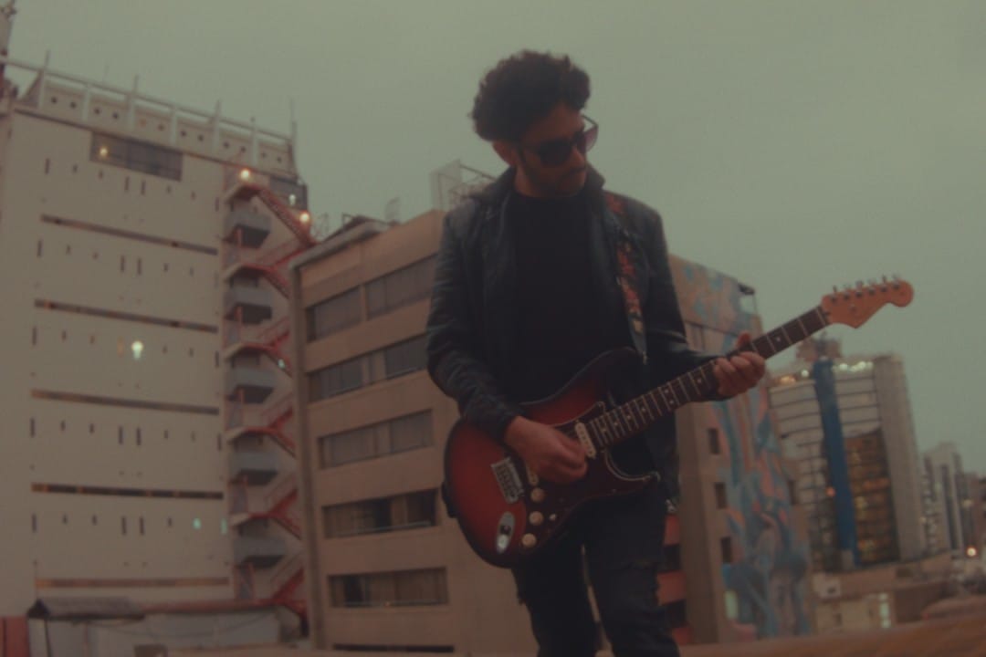 Vocalista de Imposible Abraham Palomino tocando guitarra