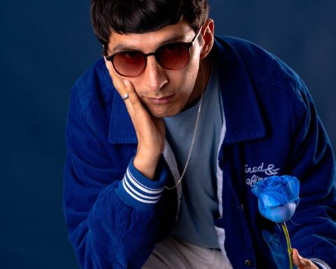 Just River con una casaca azul sosteniendo una flor azul