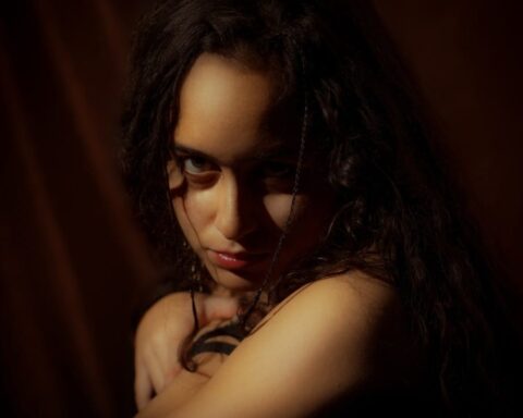 Kelly Aliaga posando con un telón rojo de fondo