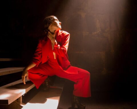 Moncaya posando en una escalera vestida de rojo