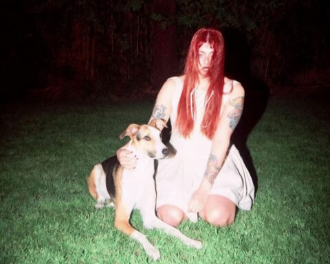 Odd Mami sentada con un perro en un jardín