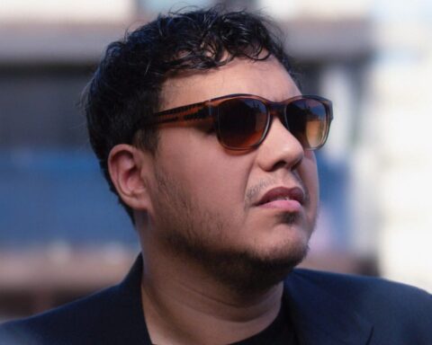 Hefe posando en exteriores con lentes oscuros, de perfil