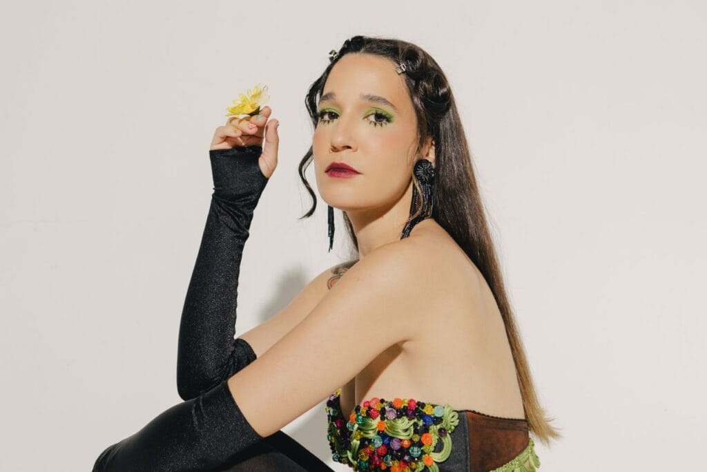 iLe sosteniendo una flor en la foto promocional de su sencillo "Me Hiciste Quedar Mal"