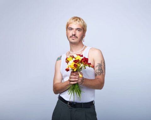 Ivo Ferrer posando sostiene un ramo de flores