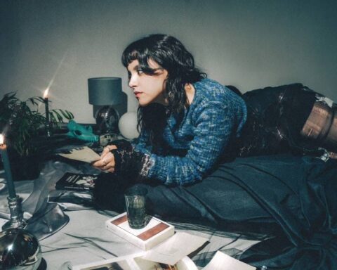 Safo echada sobre un colchón en una habitación a la luz de las velas