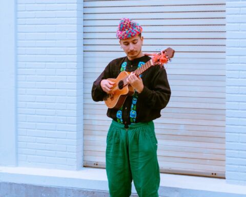 Susobrino tocando un charango vestido de negro y verde