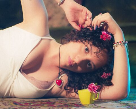 Arantxa recostada con una rosa en el cabello