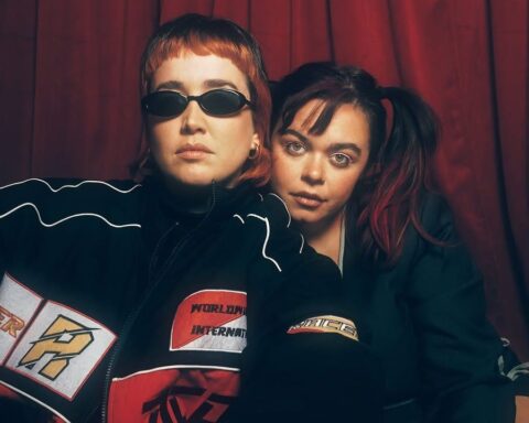 Vanessa Zamora y Maye con un telón rojo de fondo