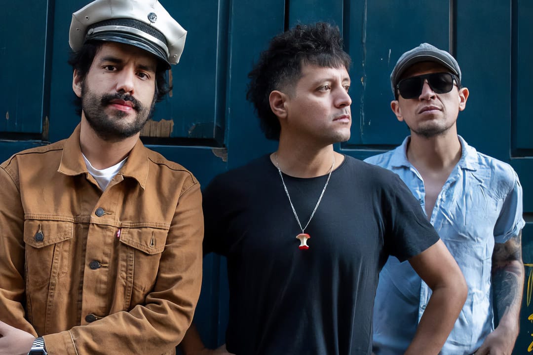 Los Outsaiders posando con una puerta verde detrás