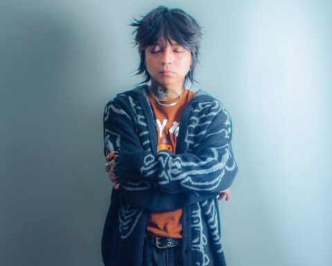 Bautista con un traje azul en fondo celeste