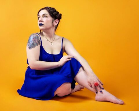 Amanda Tovalin vestida de azul con un fondo amarillo