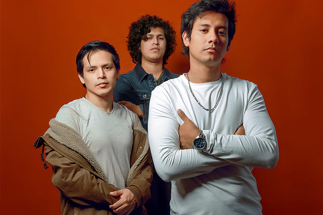 Integrantes de Artibüs posan frente a un fondo rojo