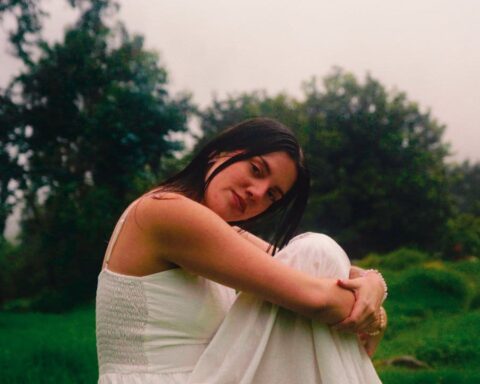 Belu con vestido blanco sentada en un bosque