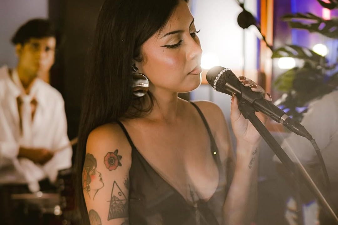 Diana Flores posando con el micrófono en el estudio