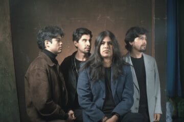 Estación Abisal posando con blazers y fondo oscuro