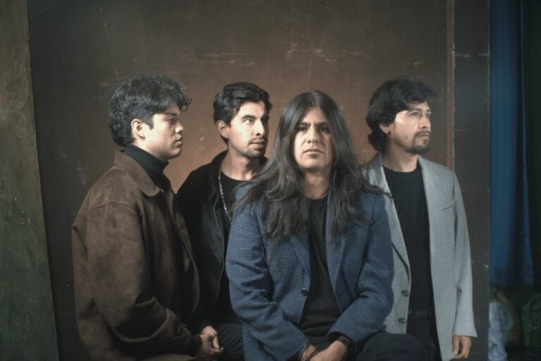 Estación Abisal posando con blazers y fondo oscuro